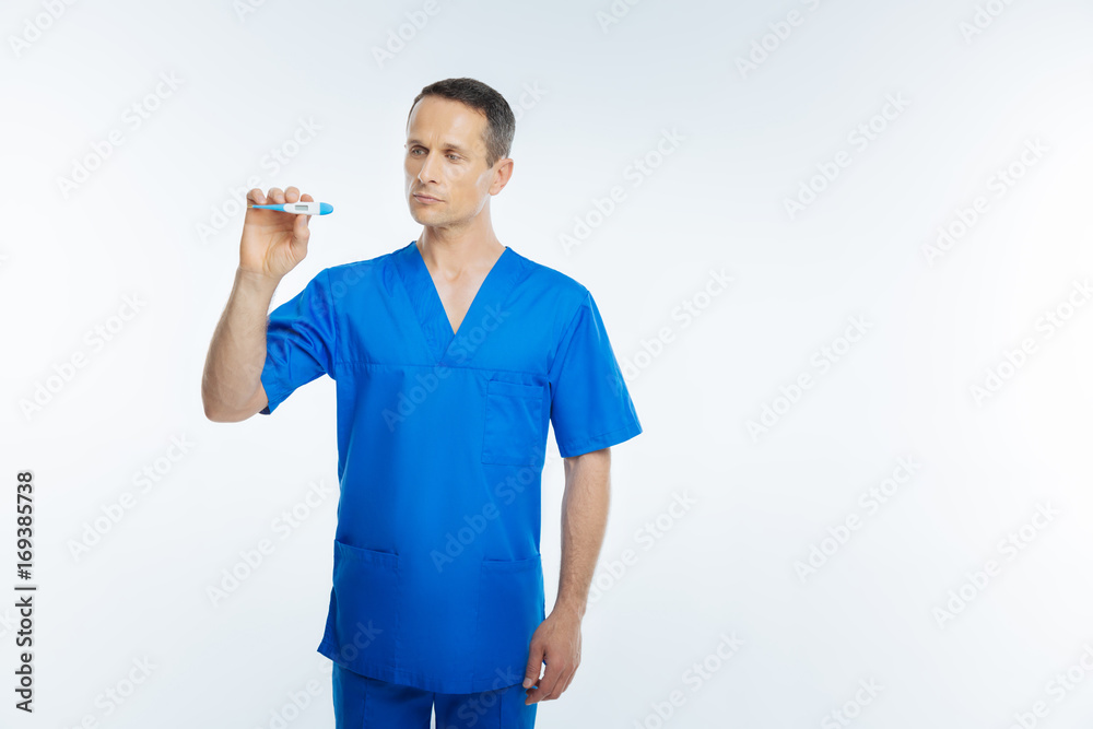 Male practitioner focusing on body thermometer Male practitioner focusing on body thermometer