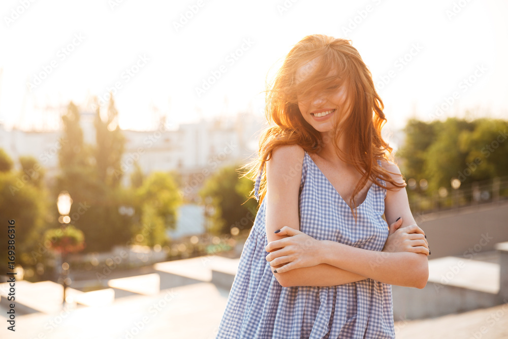 Attractive happy girl standing with arms folded