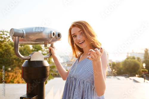 Young smiling girl standing at the telescope