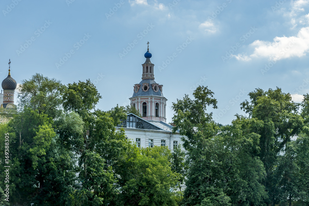 Russian Orthodox Church under blue sky and behind  trees