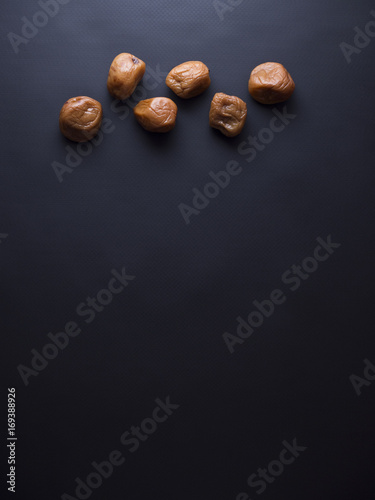 Umeboshi plums from Japan, fermented and salted and placed in a honey syrup. Isolated on black background