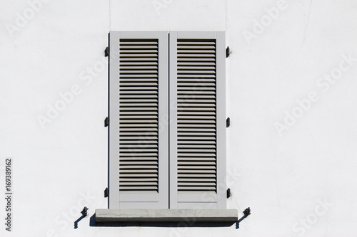Closed shutter window on a white wall