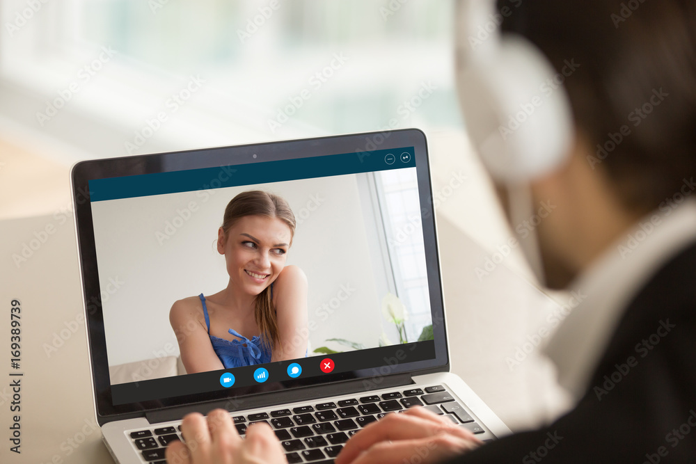 Shy teen girl on video call with boyfriend, couple talking by  videoconferencing app, young woman embarrassed during virtual chat with  man, distance relationships, focus on screen, close up rear view Stock  Photo