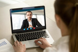 Businesswoman calling businessman online by video chat computer app, partners negotiating online on virtual meeting, employee reporting to boss running business remotely, close up rear view
