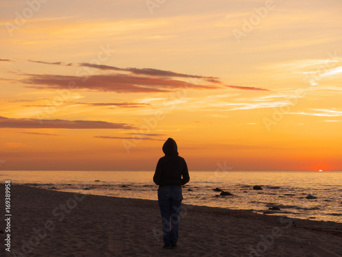 Frau am Strand schaut in den Sonnenuntergang, im Zentrum, Rügen