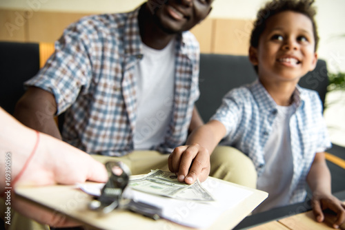 father and son paying bill