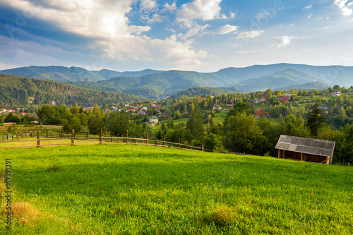 Summer grassland with wooden fence in Carpathian mountains countryside, Ukraine