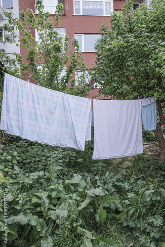 hanged clothes at garden of an building © berna_namoglu