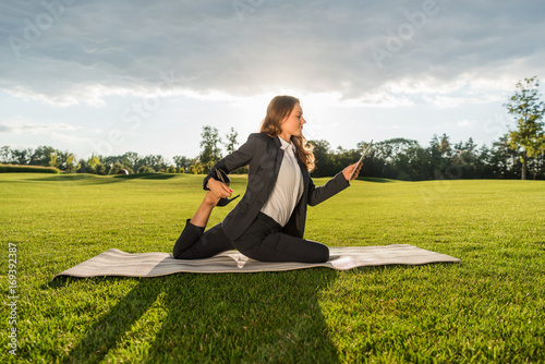 businesswoman practicing yoga with tablet photo