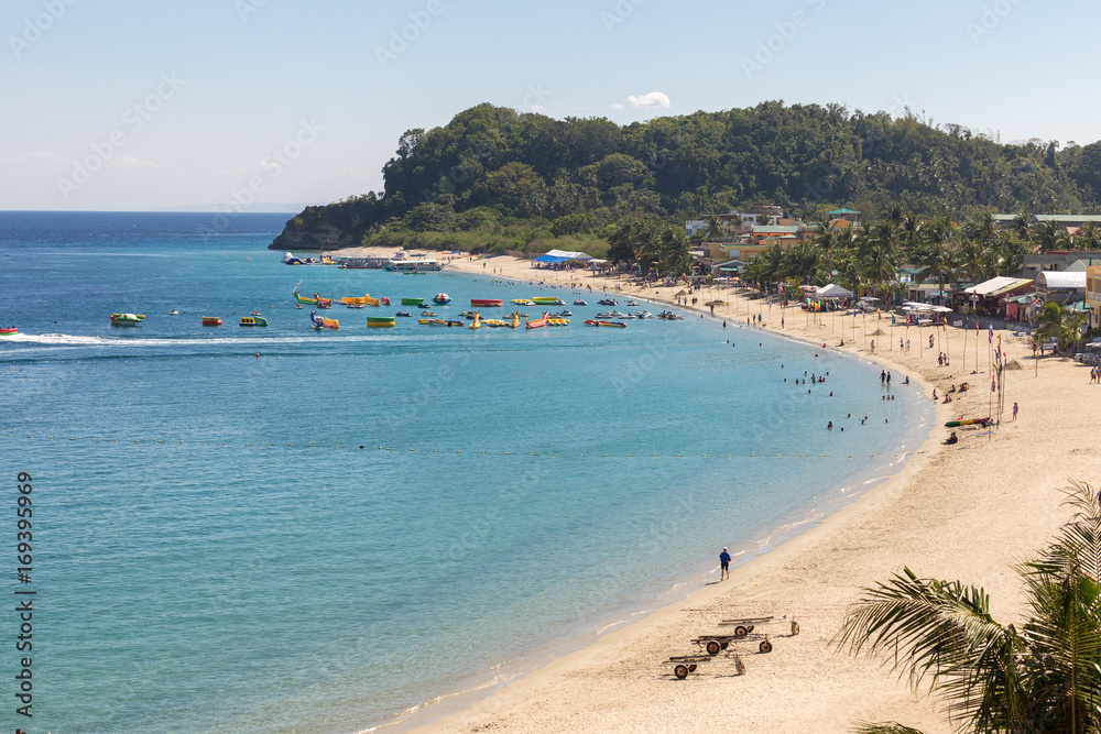 Seascape of beach with transparent sea, blue sky, palms and boats.Taken Sabang, popular tourist and diving spot.    