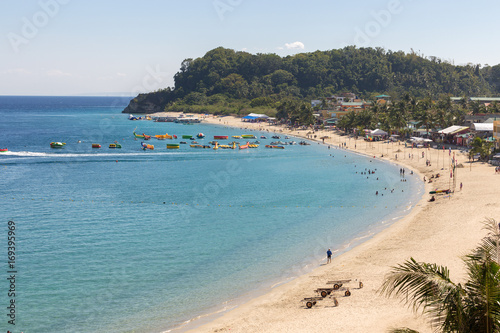 Seascape of beach with transparent sea, blue sky, palms and boats.Taken Sabang, popular tourist and diving spot.     photo