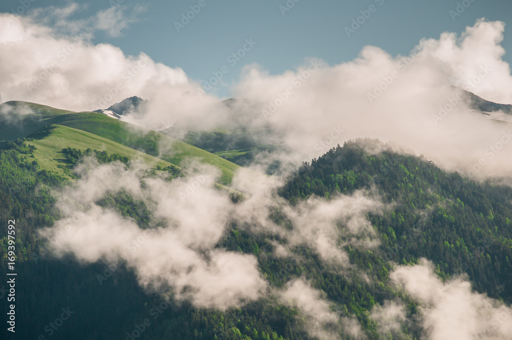 Obraz premium Large clouds cover high peaks