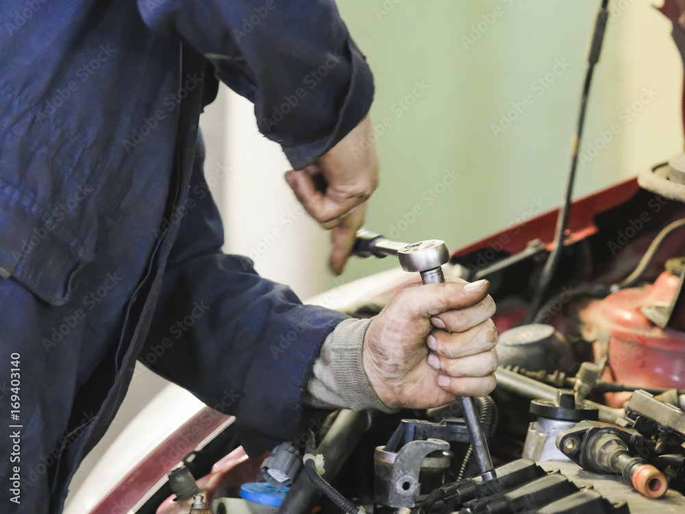 Worker repairs a car in a car repair station Worker repairs a car in a car repair station