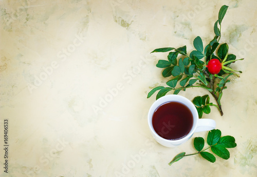 Tea from a dogrose in a mug on a light background with fruits