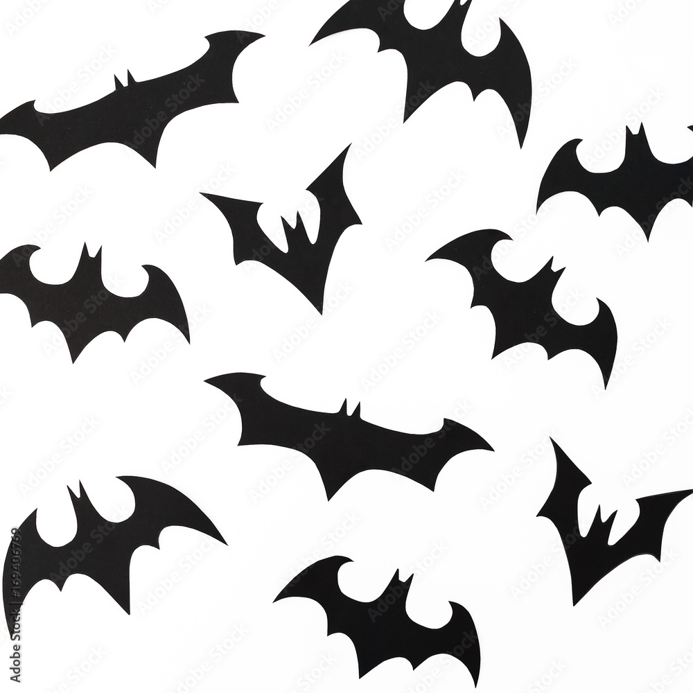 Handmade black paper bats for Halloween holiday on white background. Flat lay, top view. Handmade black paper bats for Halloween holiday on white background. Flat lay, top view.