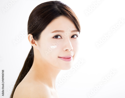 beautiful woman face with cosmetic cream.