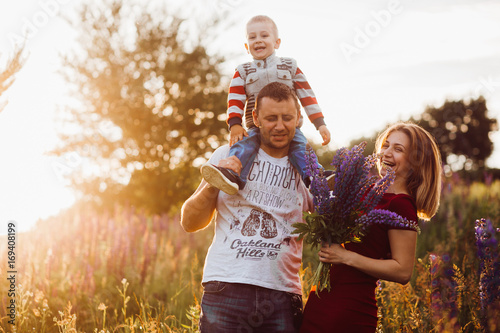 Happy family couple with little son pose on the field of lavander