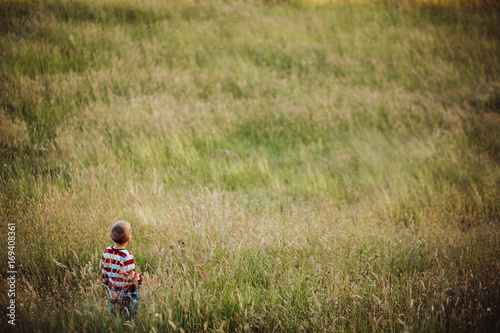 Little boy runs on green field