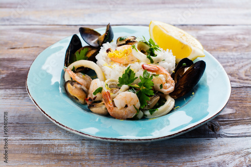 Εκτύπωση καμβά Seafood saute with rice on blue plate. Copy space
