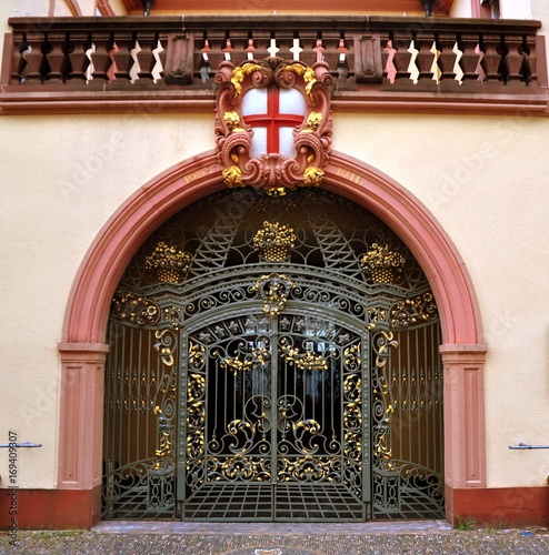 Schmiedeeisernes Eingangstor unter Rundbogen mit dem Wappen Freiburgs photo