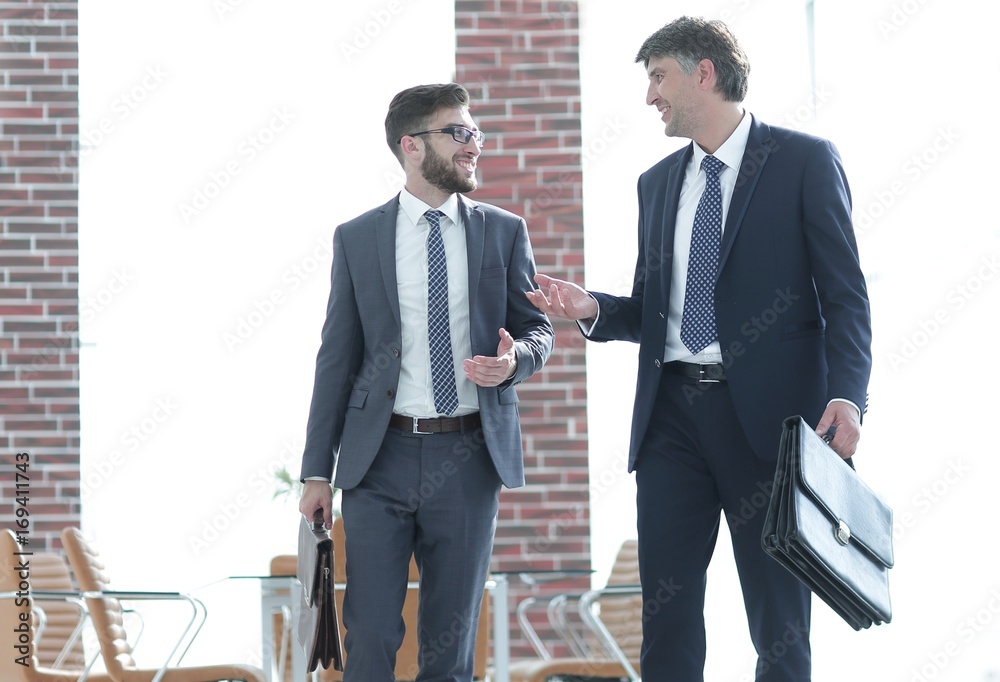 business partners walking down in office building and talking business partners walking down in office building and talking