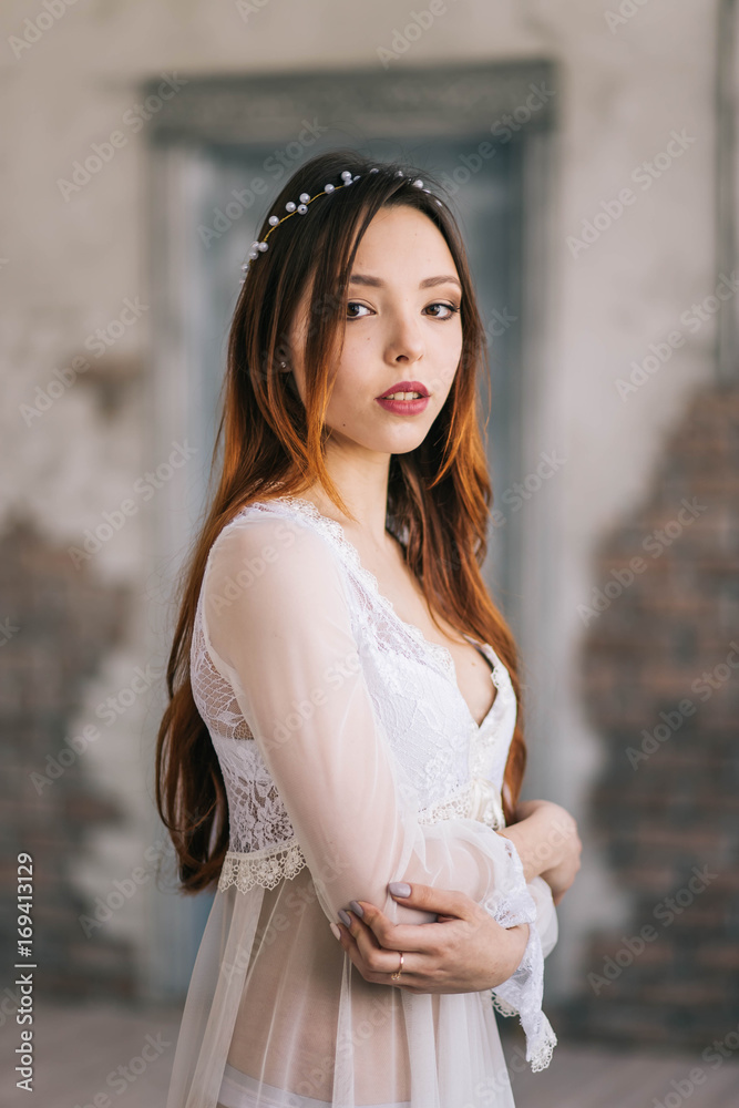Beautiful redhead girl, the boudoir bride in the white dress looks, portrait Beautiful redhead girl, the boudoir bride in the white dress looks, portrait