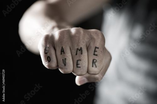 text game over in the knuckles of a young man photo