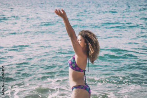 Out of focus portrait of happy and cheerful woman taking a bath in the sea