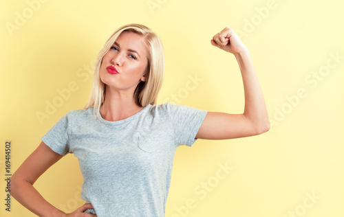 Powerful young woman on a yellow background