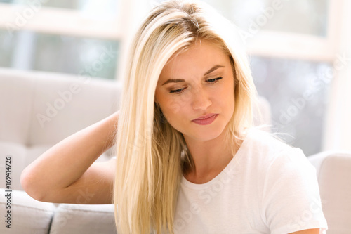 Young blond woman relaxing at home in her living room