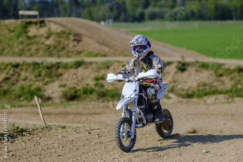 child rider riding a motor cross bike off road