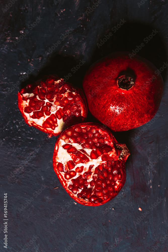 red sliced pomegranate on a blue abstraction background red sliced pomegranate on a blue abstraction background