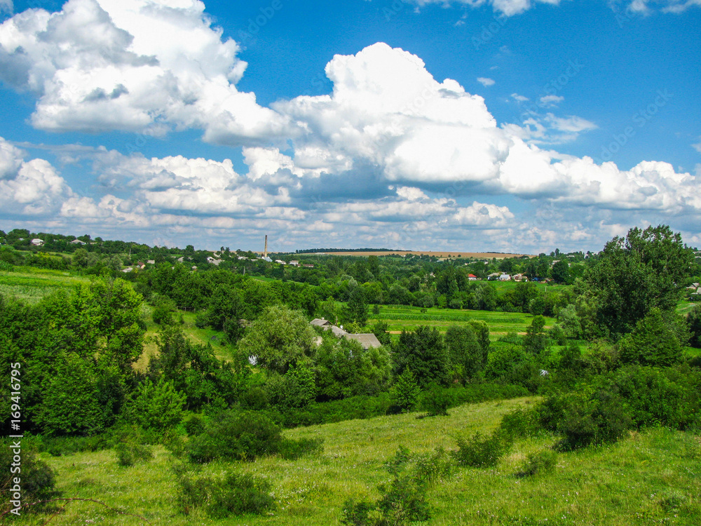 Obraz premium The Summer rural landscape amidst beautiful clouds