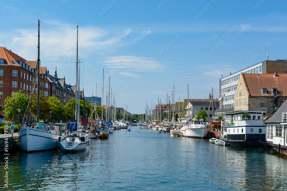 Water canal in Copenhagen on a sunny day with plenty of parked boats