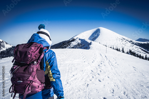 Girl walking on snowy european mountains, Young sportswoman looking at top of snowy mountain, Confident woman in Mountains, Vintage winter background with woman