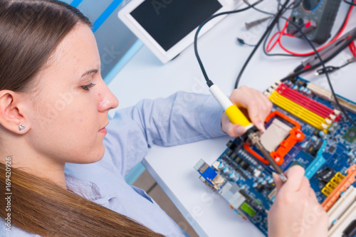 Young woman fix PC component in service center