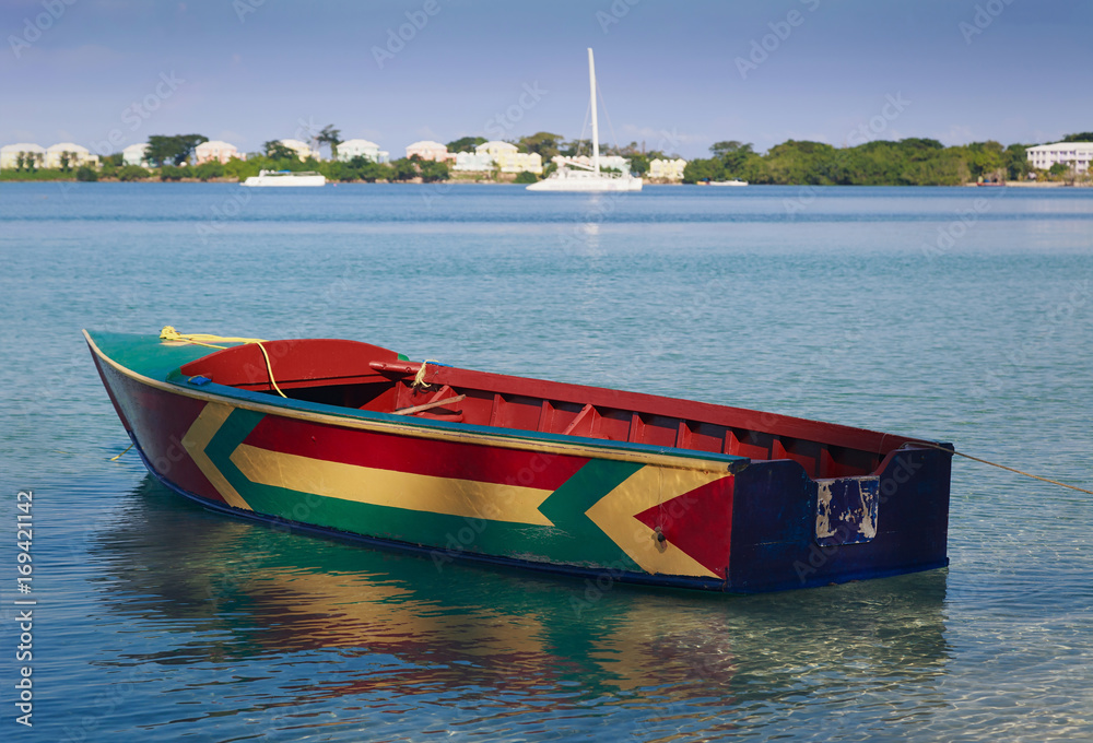 Traditional Jamaican fishing boat floating out from the beach on Bloody ...