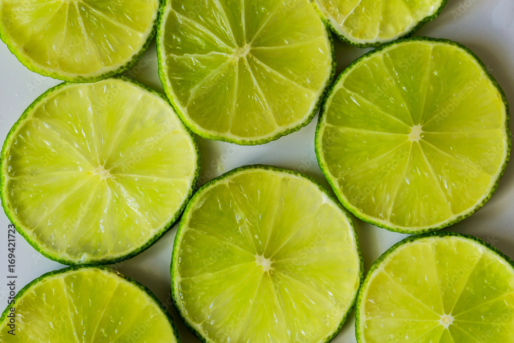 Close-up of lime slices on a white background, suitable for texture and background. Health concept.