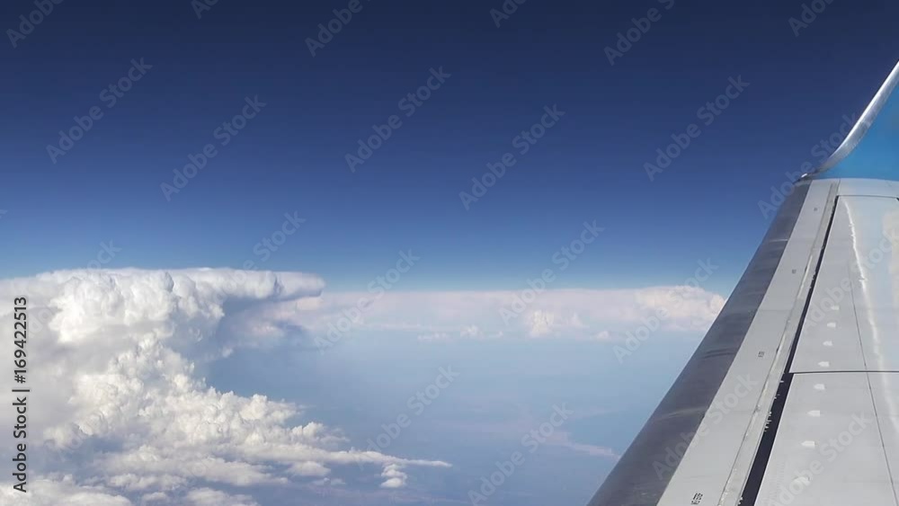 Flying over the clouds. View from plane aircraft passenger window. Clouds and skyline horizon panoramic view. Flying over the clouds. View from plane aircraft passenger window. Clouds and skyline horizon panoramic view.