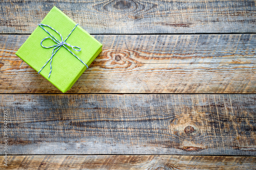 small green gift box on empty wooden table small green gift box on empty wooden table