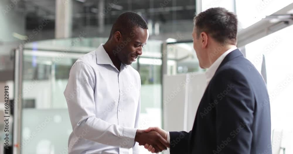 Businessmen shaking hands in a corporate office Businessmen shaking hands in a corporate office