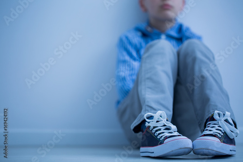 Sad boy sits alone photo