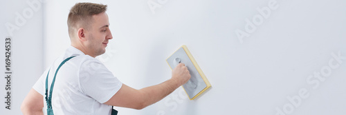 Plasterer finishing wall with float photo