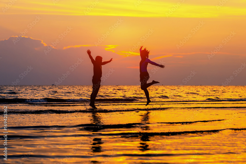 Fototapeta premium Two happy kids jumping on the beach