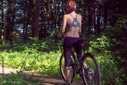 Girl cyclist on a mountain bike in a forest