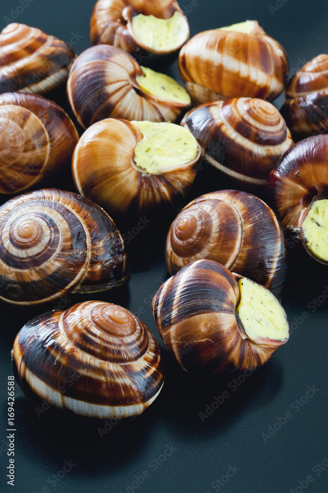Snails on a dark plate. French dish. Snails on a dark plate. French dish.