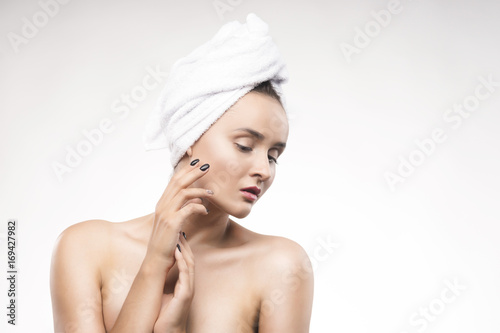 Portrait of the beautiful mature woman with a white towel on the head