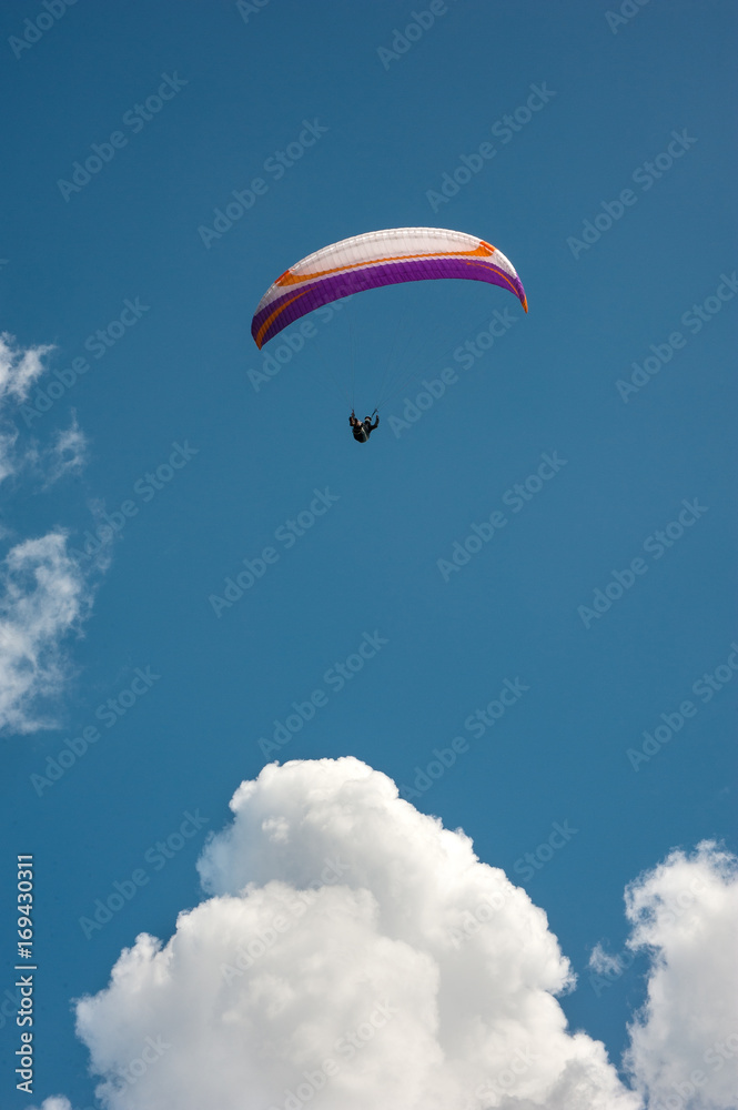 The paraglider flies in the sky above the cloud on a sunny summer day. The paraglider flies in the sky above the cloud on a sunny summer day.