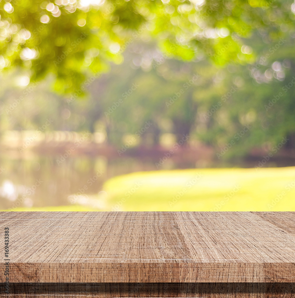 Empty wooden table over blurred tree with bokeh background, for product display montage Empty wooden table over blurred tree with bokeh background, for product display montage