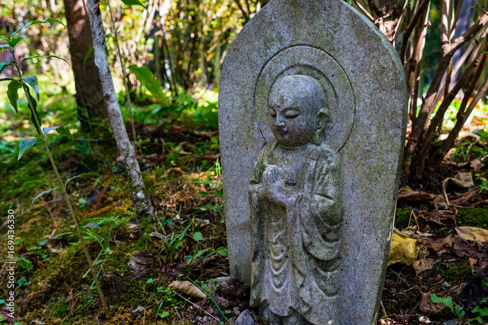 stone buddhist statue in forest, Japan stone buddhist statue in forest, Japan